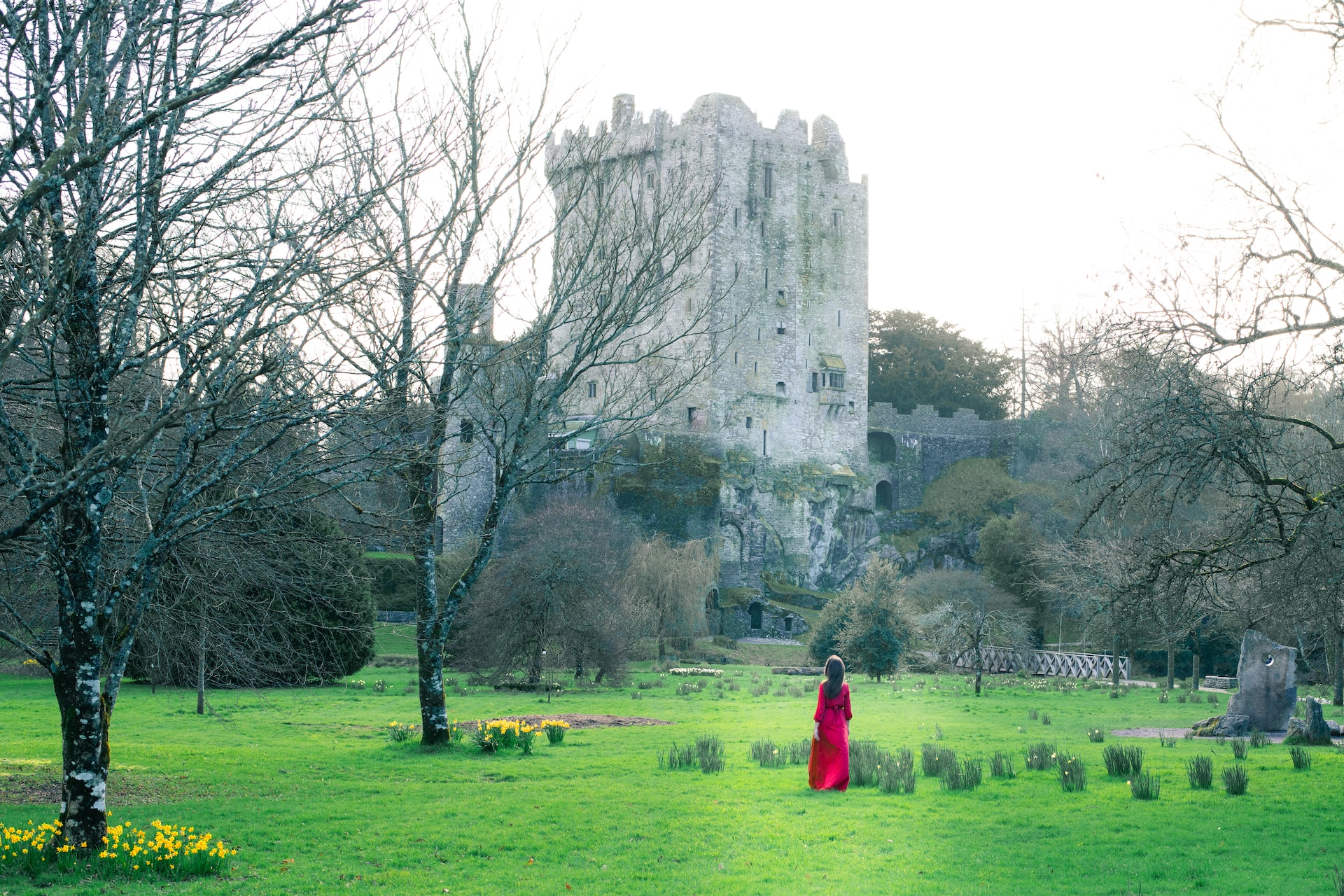 woman in red dress in the grounds of a castle